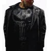 Person wearing a black leather jacket with a graphic design on the chest.