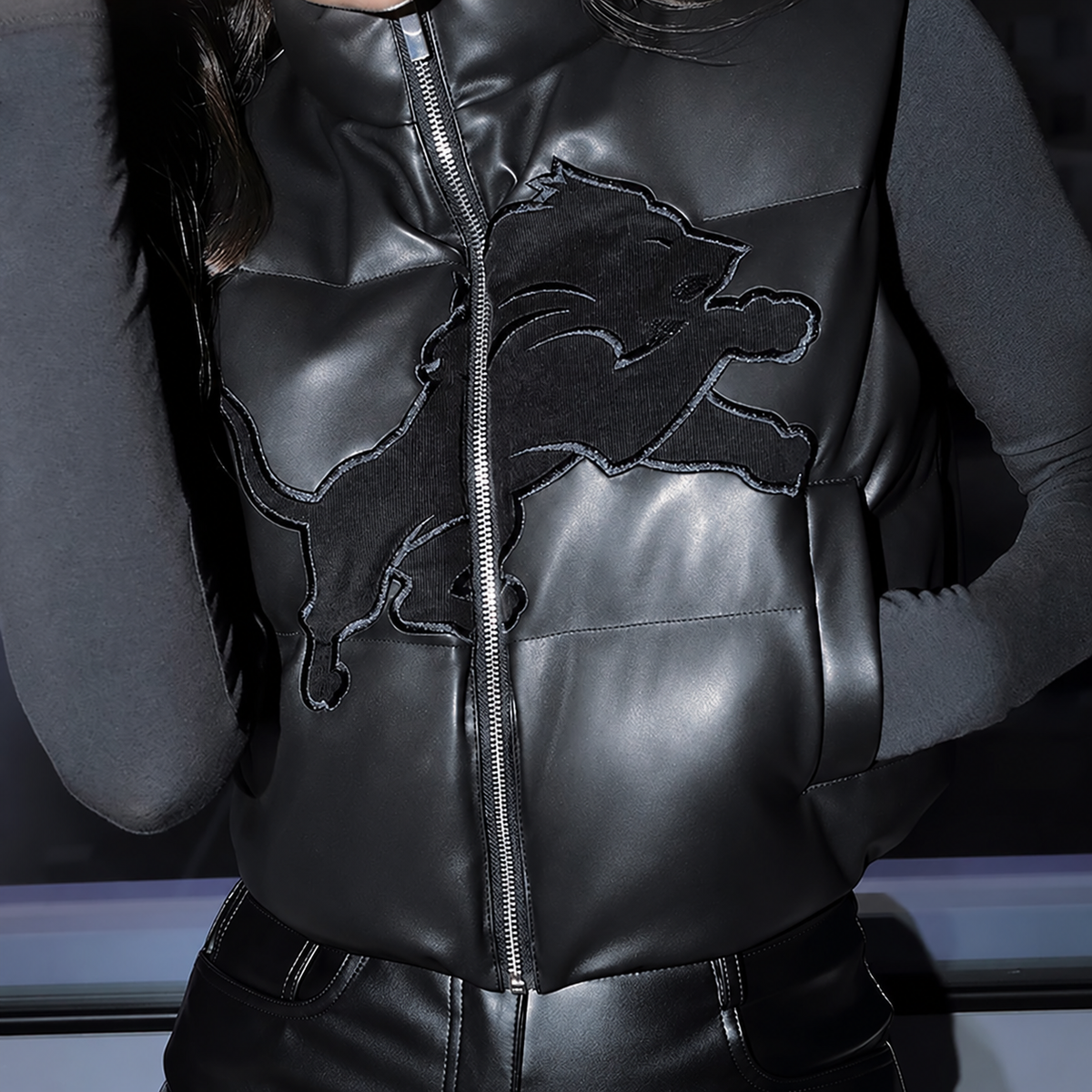Modeled front detail of Detroit Lions black faux leather cropped vest, with clean hem and no rectangular brand patch