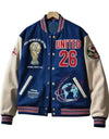 Blue and beige varsity jacket with various designs and text on a white background