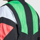 Colorful jacket with black, green, red, and white design on a plain background