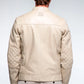 Man wearing a beige quilted jacket on a plain background