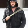 Person holding a large knife in a dark setting