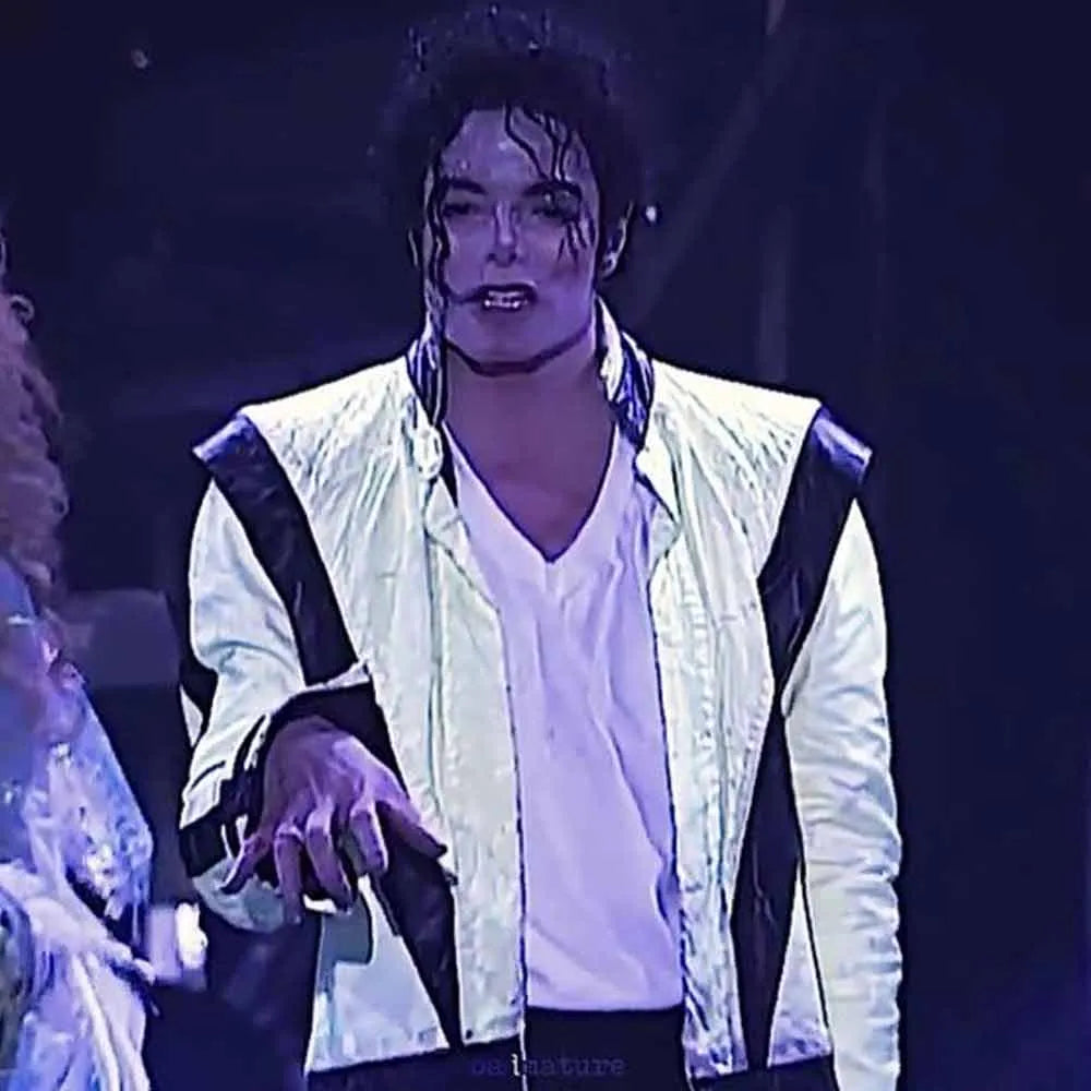 Person in a white jacket with black accents on a dark background