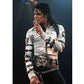 Person in a white outfit with black accents holding a microphone on a dark background