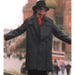 Person wearing a black coat and hat with arms outstretched, blurred background
