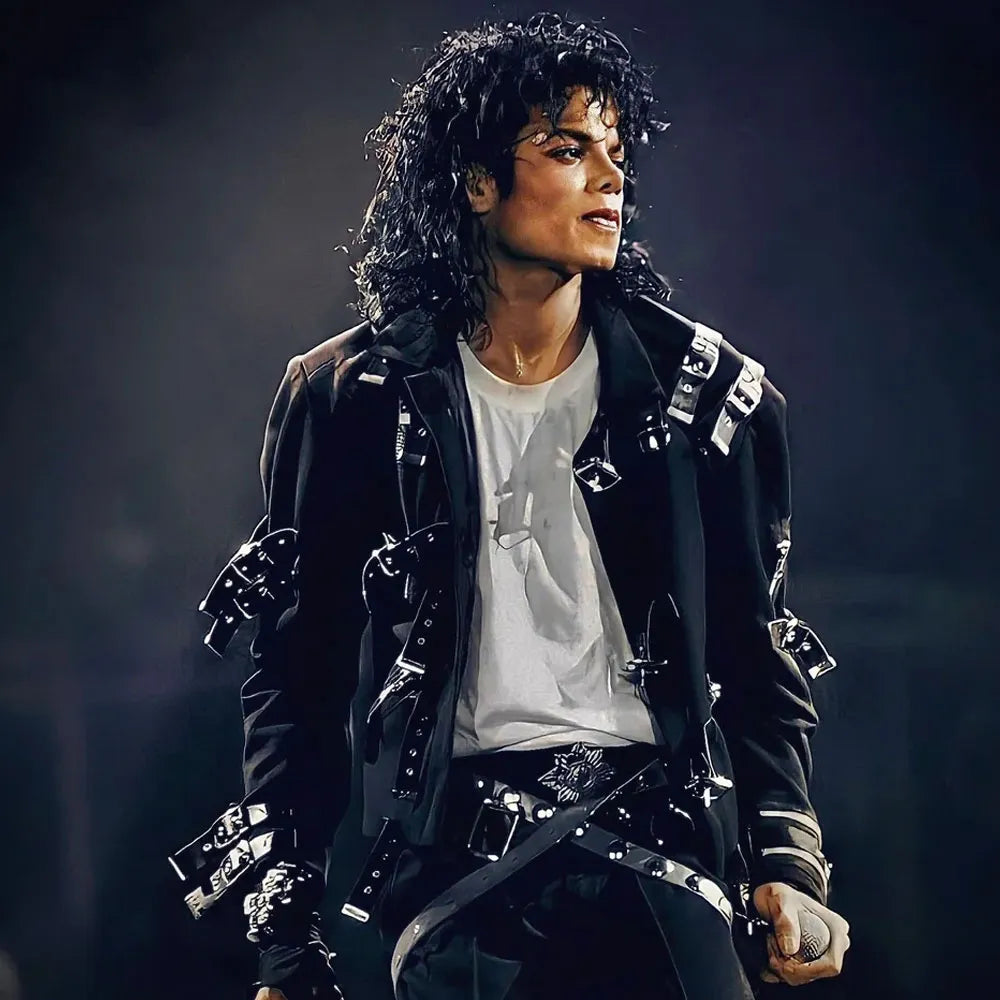 Person wearing a black jacket with silver buttons against a dark background