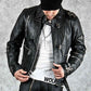 Person wearing a black leather jacket and white shirt with 'Wolfe' branding on a gray background