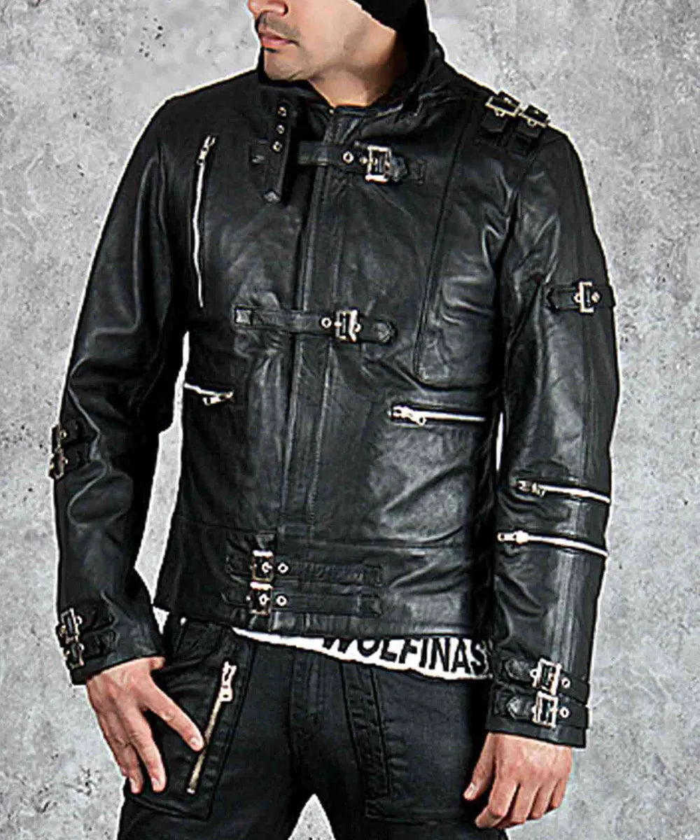 Person wearing a black leather jacket with metallic accents on a gray background