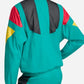 Person wearing a colorful tracksuit with green, red, yellow, and black design on a white background