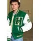 Person wearing a green and white letterman jacket with a logo on a plain background