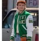 Person wearing a green varsity jacket with a logo, standing in front of a building.