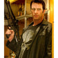 Person wearing a leather jacket and t-shirt with a skull design, holding a rifle.