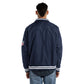 Person wearing a navy blue jacket with a logo on the sleeve against a white background