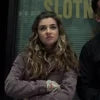 Person wearing a purple sweater with a blurred background