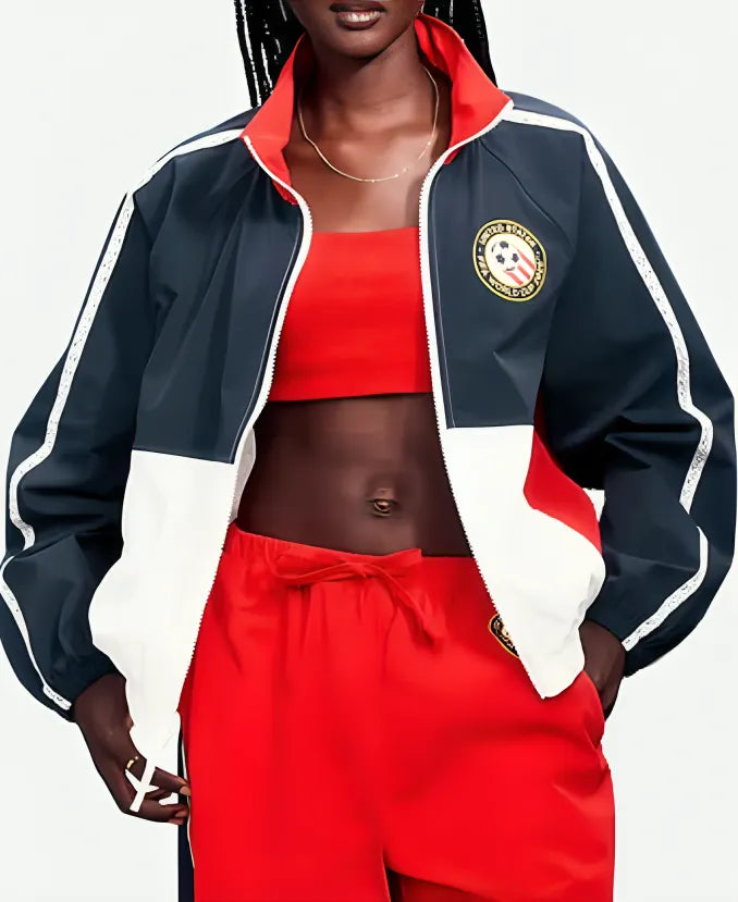 Person wearing a red and navy tracksuit with a logo on a white background