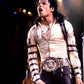 Person wearing a white shirt with black straps and a decorative belt on a dark background