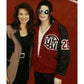 Two people posing together with a red background