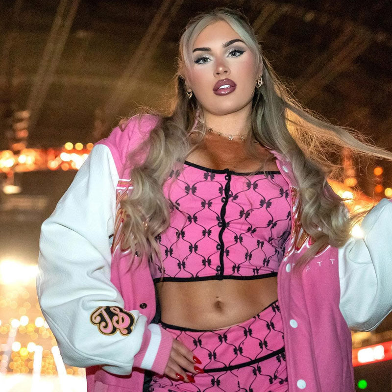 Front lifestyle view of pink Tiffany Stratton Tiffy Time full-snap varsity jacket with white leather-look sleeves