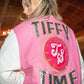 Close lifestyle front of pink full-snap varsity jacket with ribbed pink-white striped cuffs